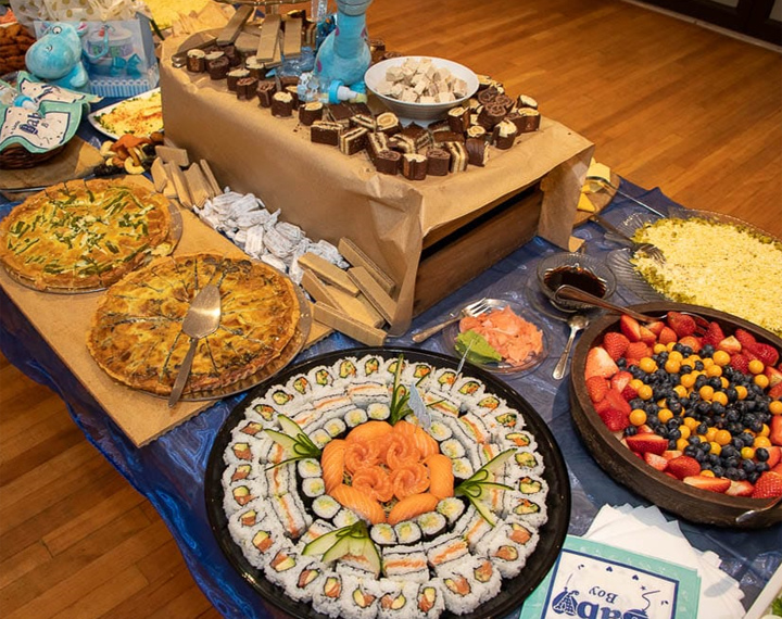  Kosher buffet table with sushi, fruit, quiche and sweet treats 